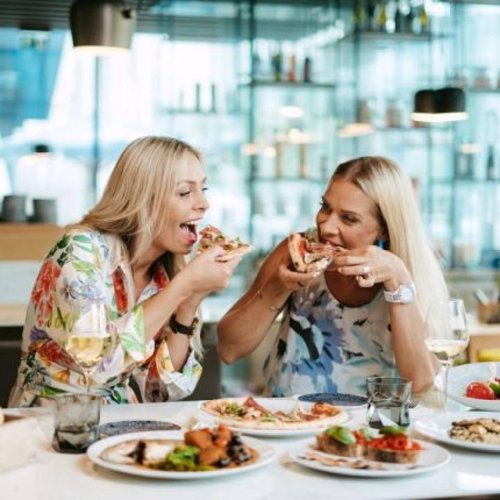 Two women enjoying pizza