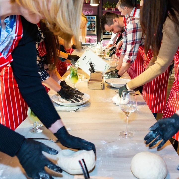 People making pizza dough at cooking school